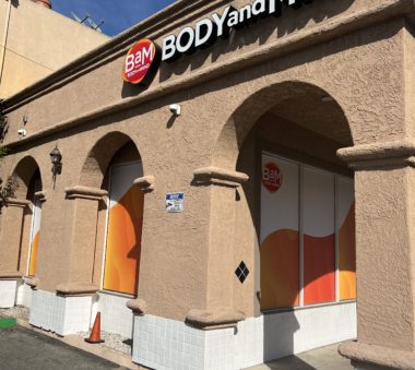 Exterior view of a building with arched windows and signage for BAM Body and Mind