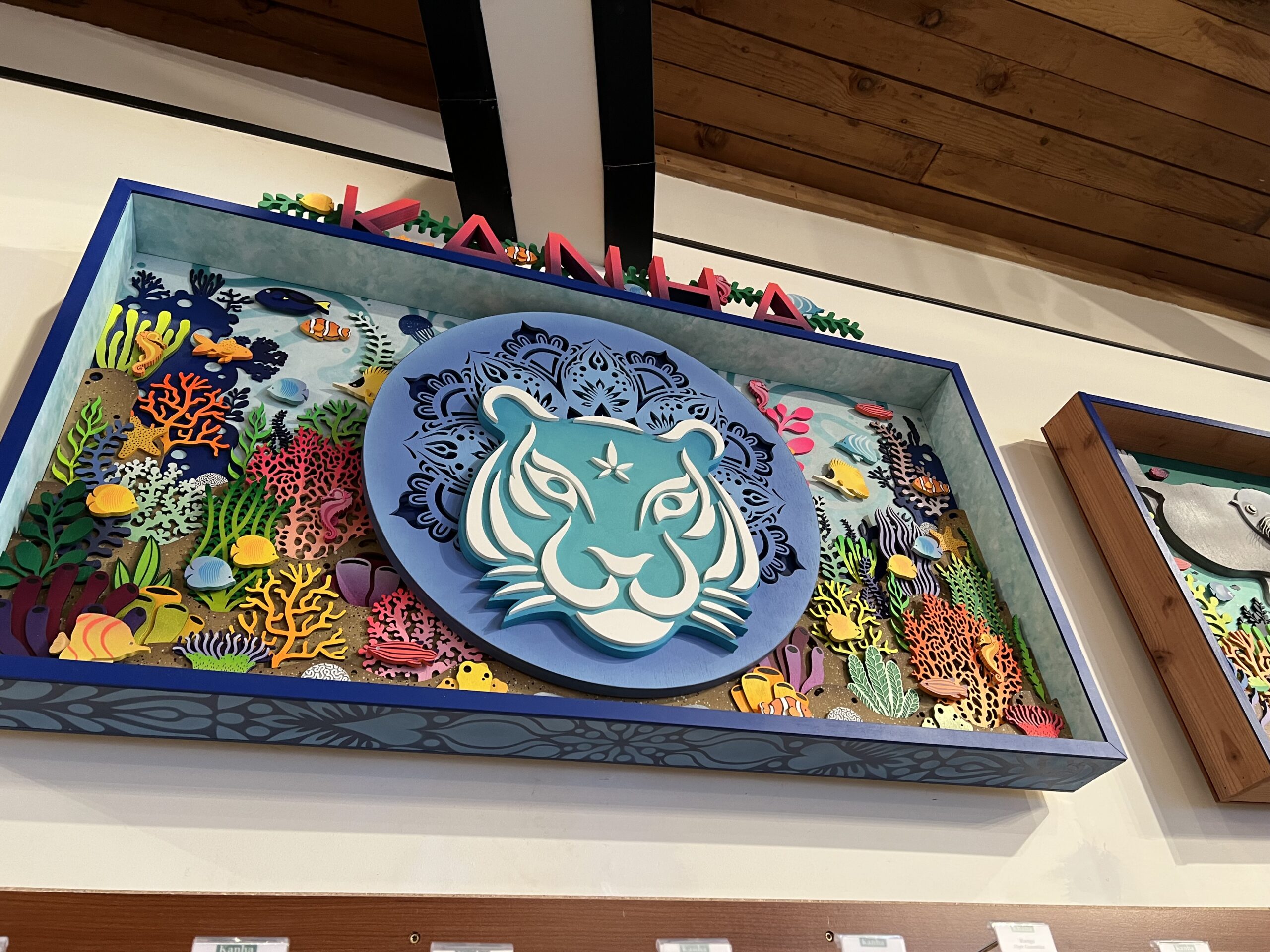 Colorful wall art featuring a stylized tiger face surrounded by vibrant coral and marine life decorations